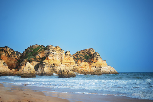 Dramatic Cliffs Along the Algarve Coastline. Ocean, rock blue sky, for travel backgrounds, wallpaper.