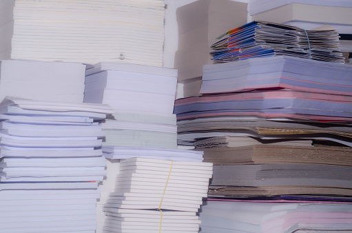 Stacks of paper products lined up with each other mostly white in smaller piles