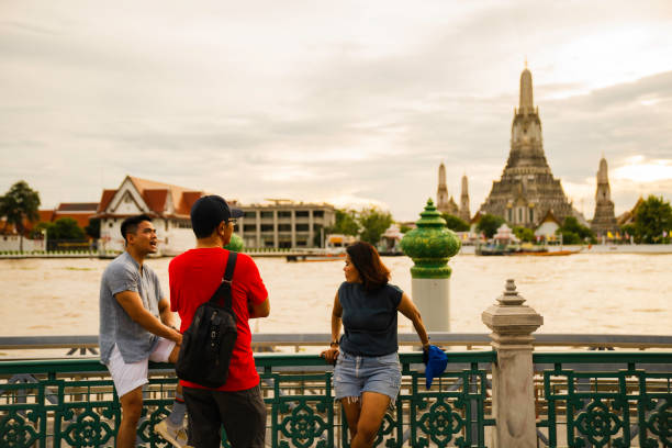 istock private tourist guide explaining the place history to group traveler Exploring with view Wat Arun Temple at sunset in Bangkok, Thailand 2005164643