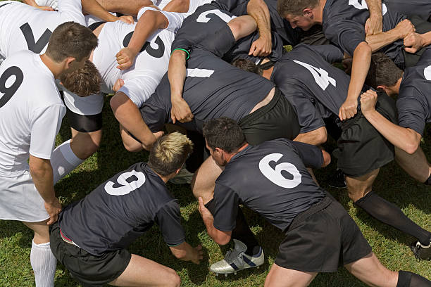 two rugby teams in scrum on pitch, elevated view - rugby scrum stockfoto's en -beelden