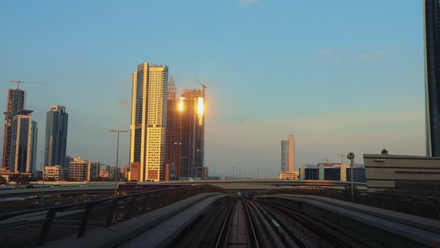 Admiring Scenic Sunset Over City Skyline While Riding Dubai Metro