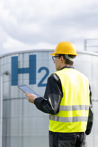 Engineer with tablet computer on a background of Hydrogen factory