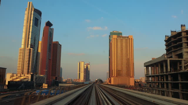 Admiring Scenic Sunset Over City Skyline While Riding Dubai Metro