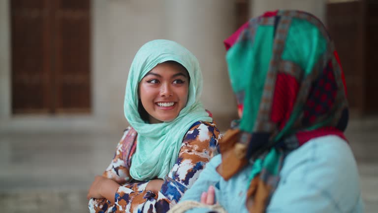 Two multiethnic female tourist friends visiting Istanbul and Blue Mosque in Türkiye Turkey