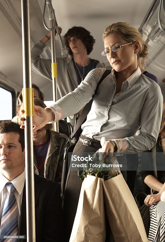 Woman carrying shopping bags on busy bus  Bus Stock Photo