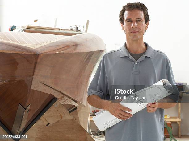 Hombre Que Agarra Planos En Embarcación Edificio De Taller Retrato Foto de stock y más banco de imágenes de 35-39 años