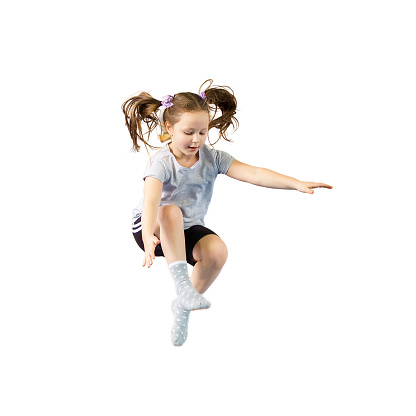 Happy little girl jumping high isolated on white background