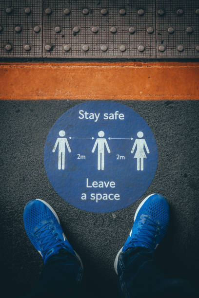 istock Top view of feet standing on blue circular sign reading 