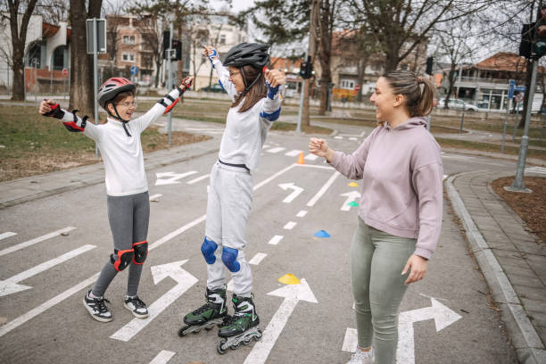 Girls learning roller skating and skateboarding in public park