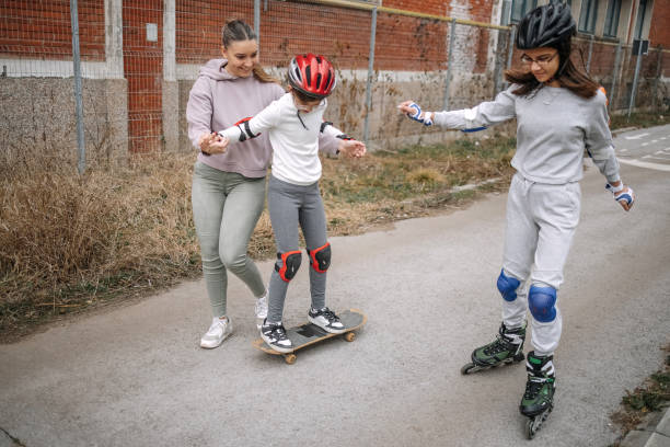 Girls learning roller skating and skateboarding in public park
