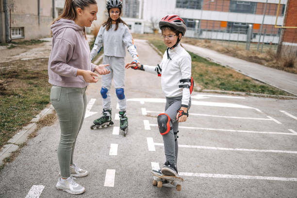 Girls learning roller skating and skateboarding in public park