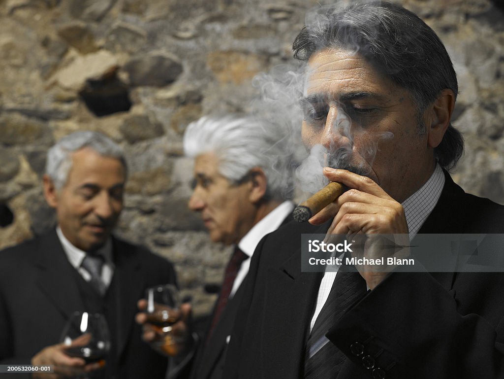 Homme d'affaires de fumer un cigare dans le restaurant, hommes d'affaires en backgrou - Photo de Cigare libre de droits