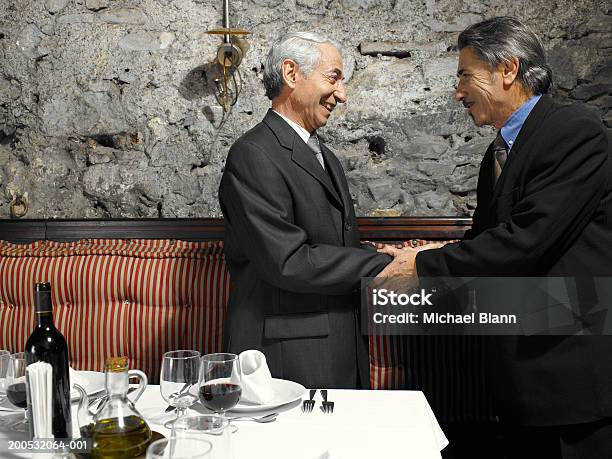 Два Старших Бизнесмен Трясти Руки В Ресторане Улыбается — стоковые фотографии и другие картинки Бизнесмен