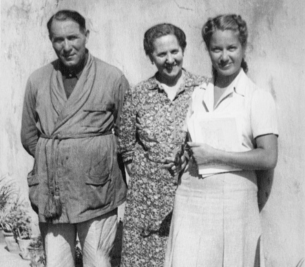 Young woman and her parents standing in a street. 1942.