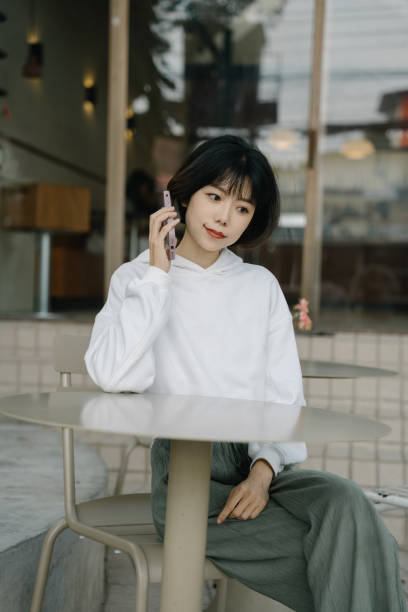 istock A young Asian businesswoman dressed in white works outdoors using a mobile phone 2005330743