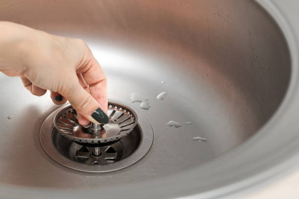 istock hand plugs the sink drain hole with a drain plug. 2005331452