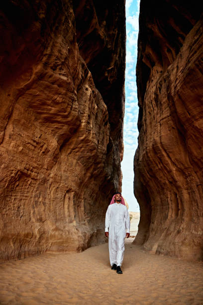 istock Smiling Saudi man walking through The Siq 2005333936