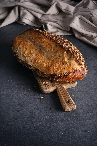 Organic homemade whole grain bread on wooden cutting board. Delicious brown bread made from whole grain flour for a healthy diet