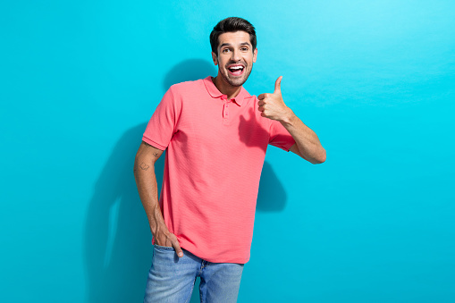 Portrait of young guy agreement with new insurance terms make thumb up like symbol good job isolated on aquamarine color background.