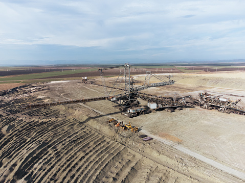 Big mining machine - excavator with a big conveyor belt on active mining site. Coal surface mine