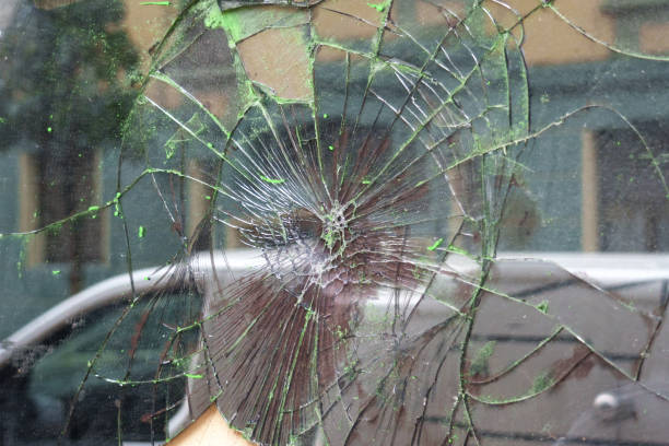 istock Broken window glass with crack lines on a urban street in reflection 2005374415