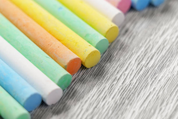 Pastel crayons on wooden surface. Colorful chalks. Close up
