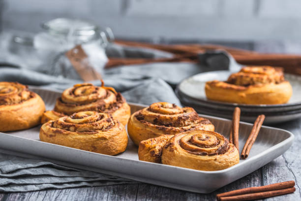 istock Homemade cinnamon rolls on a gray earthenware tray on gray background 2005390980