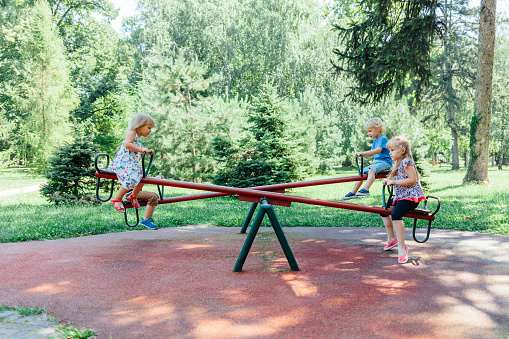 Happy children on a seesaw at playground