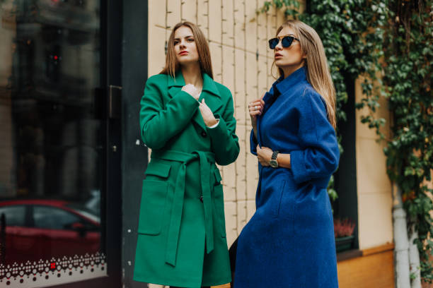 istock Two young ladies in fur coats posing on background 2005404378