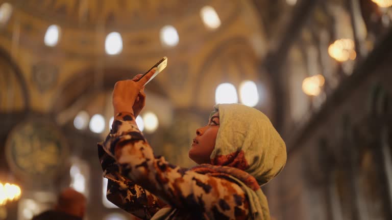 Multiracial female solo traveler visiting Istanbul and Hagia Sophia and taking photos and videos in Türkiye Turkey