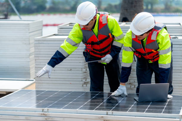 istock Two Asian professional technician workers stand near solar cell panel and use laptop to discuss about work in concept of green energy system for good environment. 2005410290