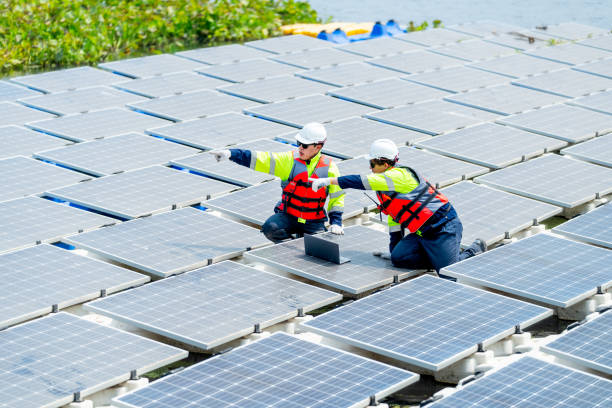 istock Two professional technician workers point together to the left and discuss about work with solar cell panel system in concept of green energy power for good environment. 2005412488