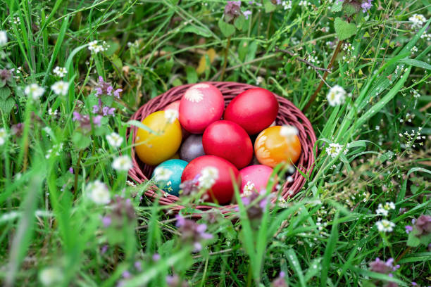 istock Basket full of colorful Easter eggs laying in the grass 2005414618