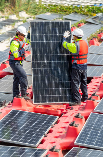 istock Vertical image of two professional technician workers stand and hold solar cell panel to check and maintenance the system in concept of green energy power plant for good environment. 2005418858