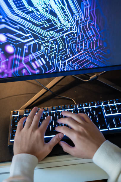 teenage boy hands are on keyboard screen is background vertical technology still