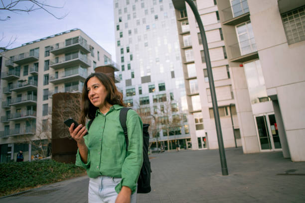 istock Latina woman walking using cell phone 2005436888