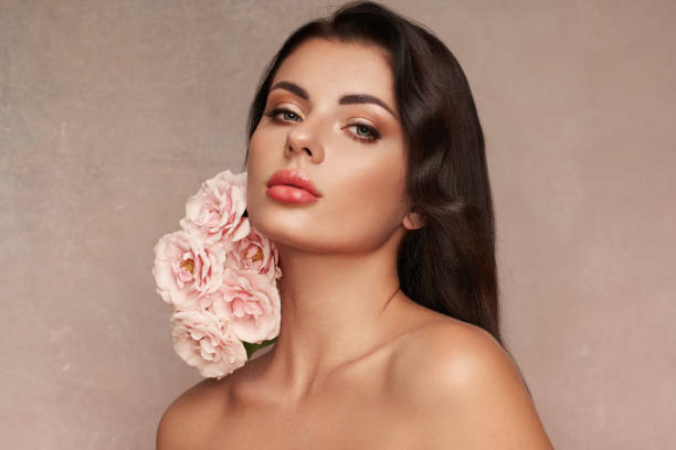 istock Beautiful young woman with a rose flower 2005440024