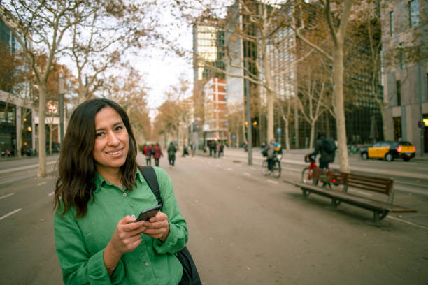istock Latina woman walking using cell phone 2005446385