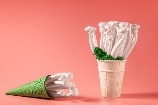 Closeup of a bunch of shimeji mushrooms with green moss in an ice cream cone, on peach fuzz background, superfood, a type of delicious oyster mushroom, healthy food, with copy space