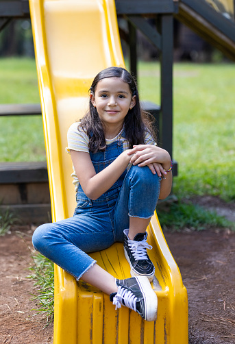 Portrait of girl looking at the camera sitting on the slide