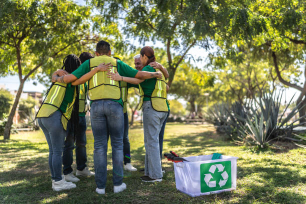 African american volunteer holding a box with plastic bottles and people recycling different materials isolated on white background