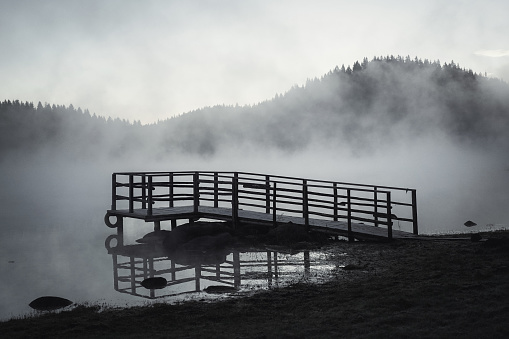 Spooky black and white dock on a foggy morning in the mountains.