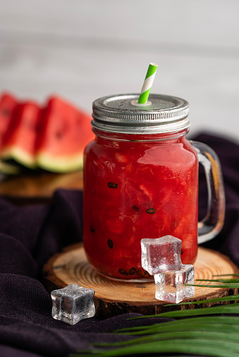 Fresh Watermelon juice in a mason jar and sliced watermelon on the background, Summer special healthy refreshing smoothie