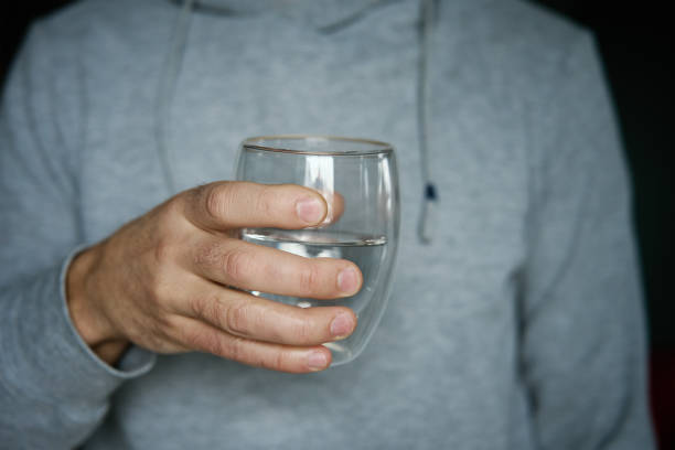 istock Man holds glass of clean water 2005491357