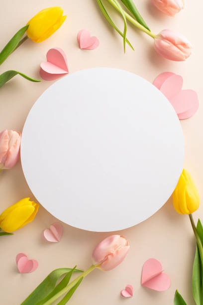 istock Woman's Day love: vertical top view splendid array of tulips and hearts, set against a soft beige backdrop, leaving empty circle for your personal message 2005515045