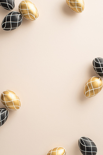 Easter piety occasion concept. Top-view vertical image of regal black and gold eggs, orderly distributed on a pastel beige groundwork, with blank space for inscriptions or promotional material