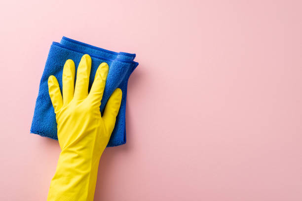 istock Ideal for housekeeping tasks, this image showcases a hand in a rubber glove, effortlessly wiping with a microfiber cloth on a soft pink surface, leaving ample space for text or advertising 2005516176