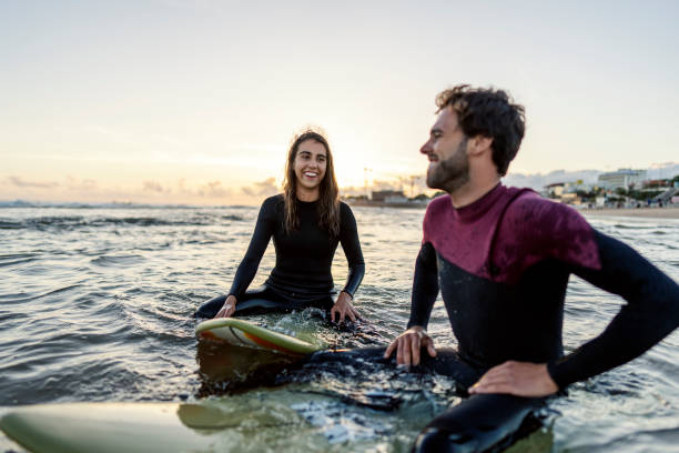 istock Happy couple on surfboards floating on the sea. 2005532535