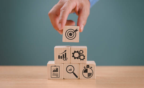 istock Goal setting planning focus for future. Goal aim target concept. Hand push target board on wooden cube block icon for creative set up business success objective. Achievement winner business project 2005541080