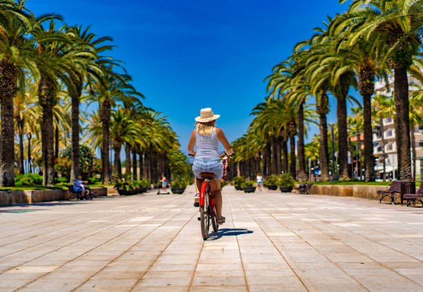 Mid adult woman riding bicycle at seaside